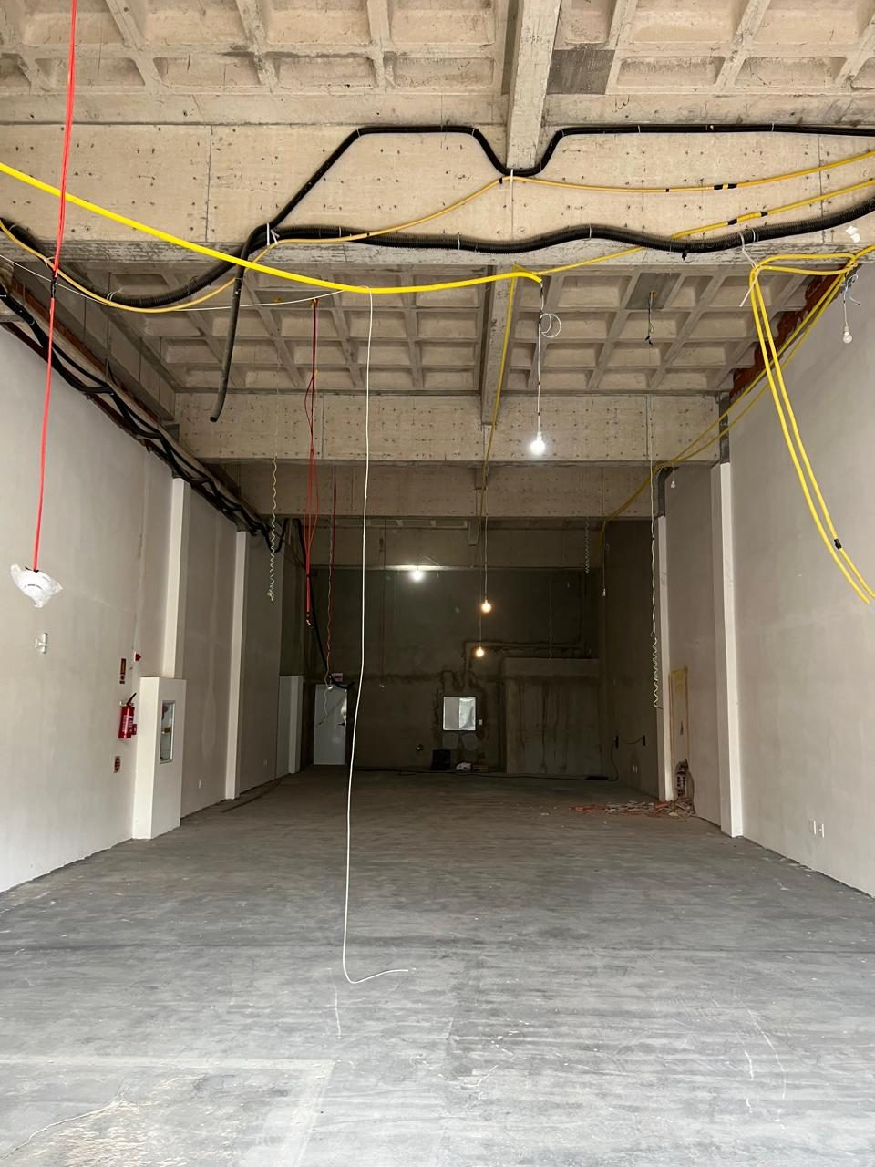 Antes: espaço em obra com laje e instalações aparentes