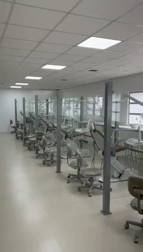 Vídeo: clínica odontológica com fileiras de consultórios, cadeiras e bancadas brancas